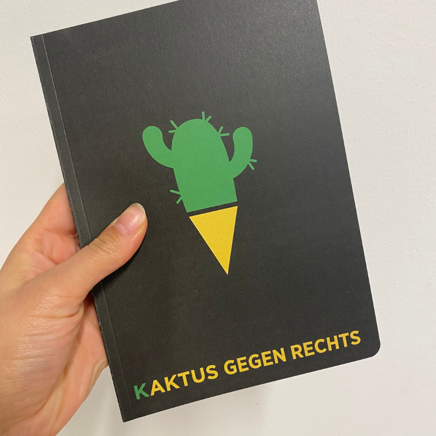 Person hält das Notizbuch "Kaktus gegen rechts" vom Katapult Verlag in der Hand