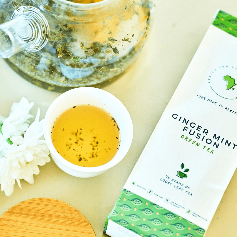 Kazi Yetu Tee Ginger Infusion 75 g loser Tee – Verpackung von vorne , daneben aufgebrühter Tee und Zutaten in Schälchen