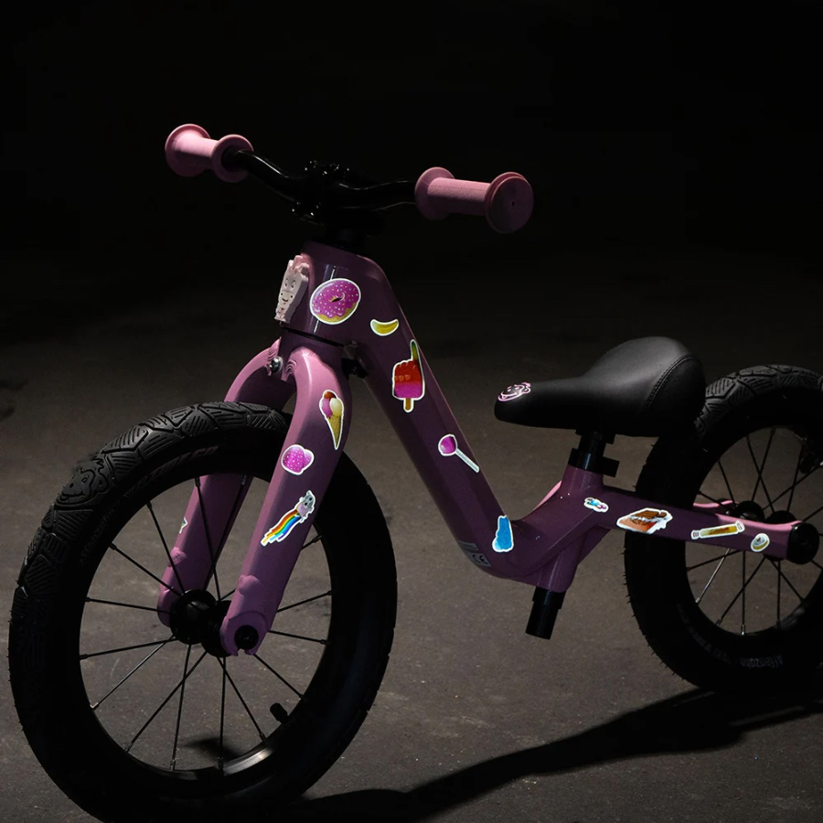 Reflexierende Sticker & Formen – Größe M. Motiv Sweets an einem rosa Kinderfahrrad im Dunklen