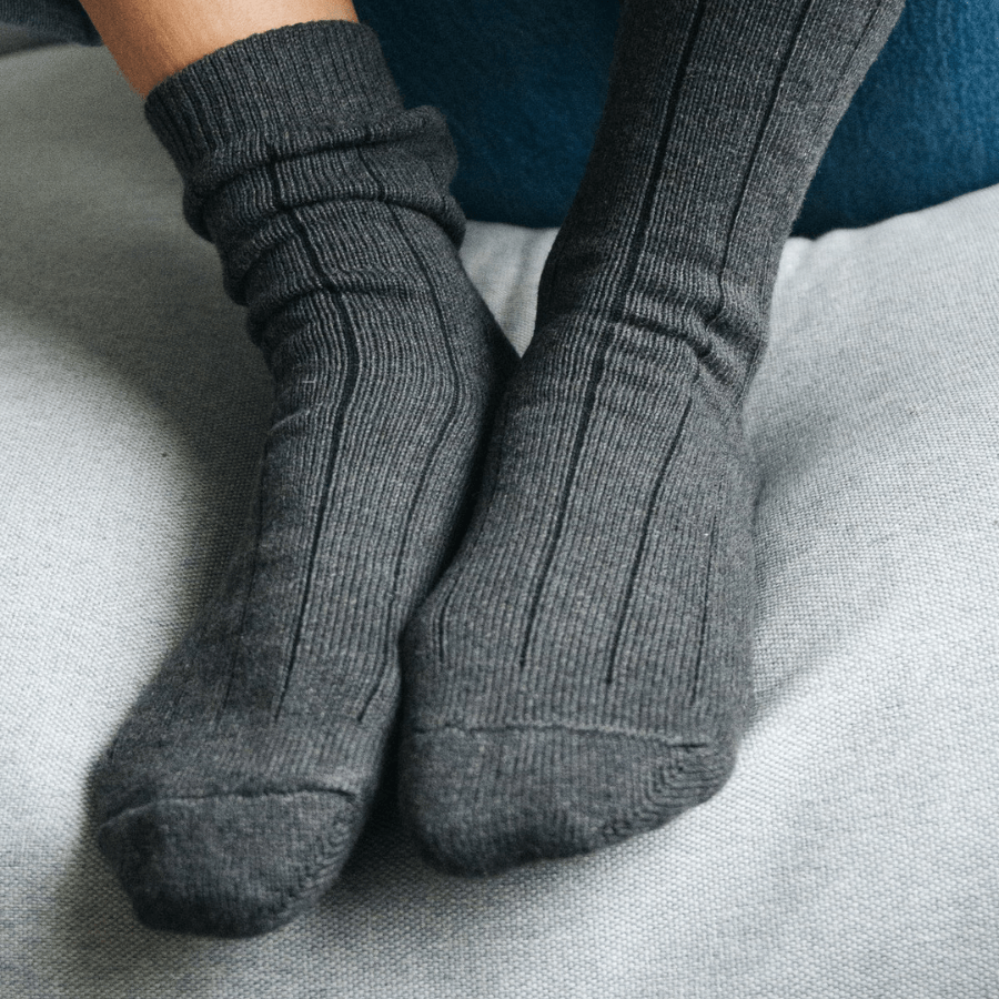 Zwei Füße mit Stricksocken von Salzwasser – Anthrazit