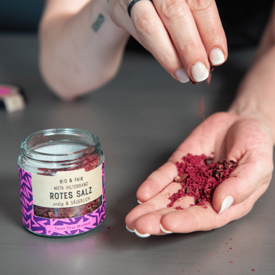 Person streut das rote Salz von SoulSpice auf die Hand