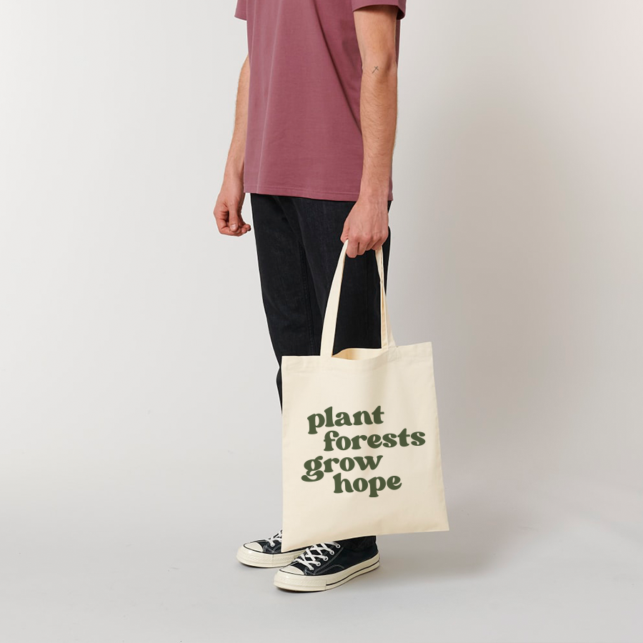 Person steht und hält den Jutebeutel Hope von The Generation Forest
