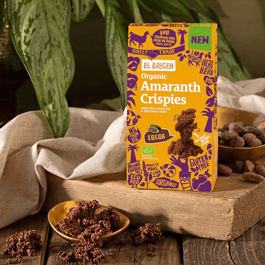 Amaranth Crispies Verpackung und Crispies mit Pflanzen im Hintergrund