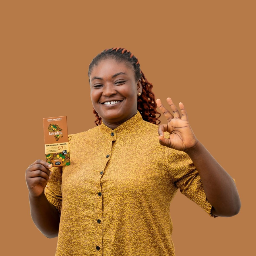 Person hält eine Tafel Zartbitter-Schokolade Macadamia & Karamell (57%) von fairafric in der Hand