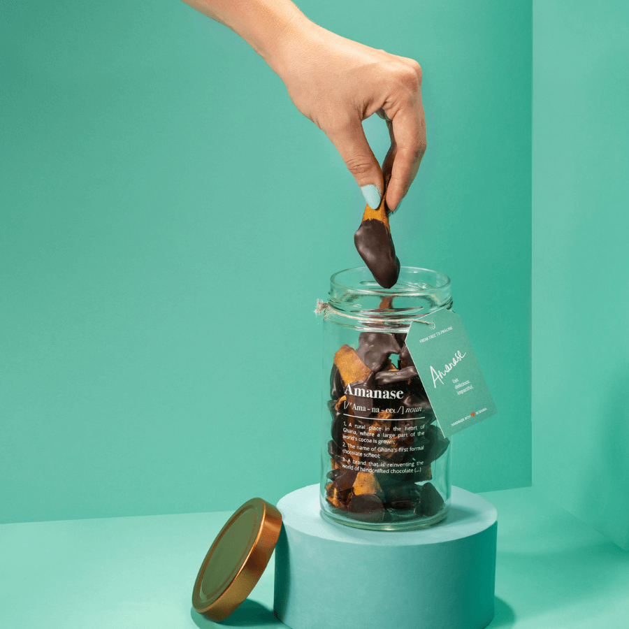 Hand greift in das Glas der Dipped Mango von Amanase