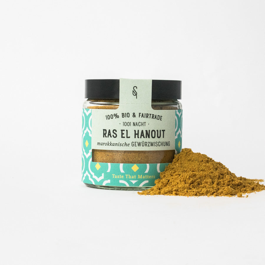 Ras el Hanout in Glasverpackung mit Gewürzhäufchen von vorne