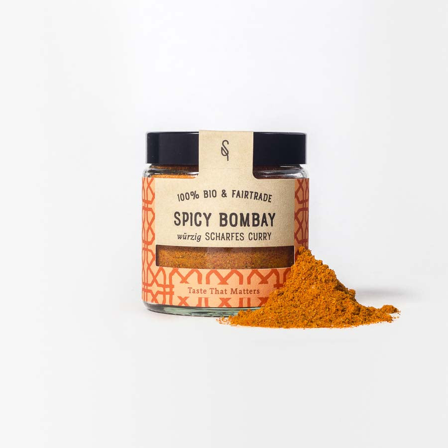 Spicy Bombay in Glasverpackung mit Gewürzhäufchen von vorne 