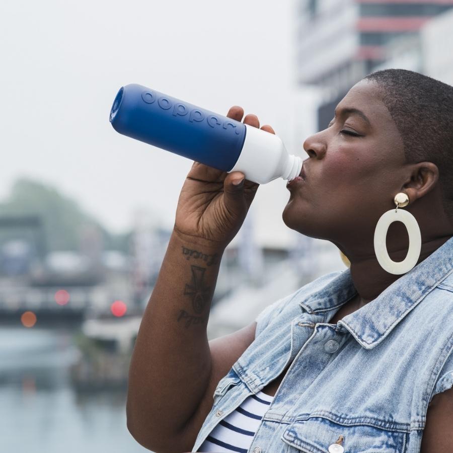 Frau trinkt aus Dopper Trinkflasche blau