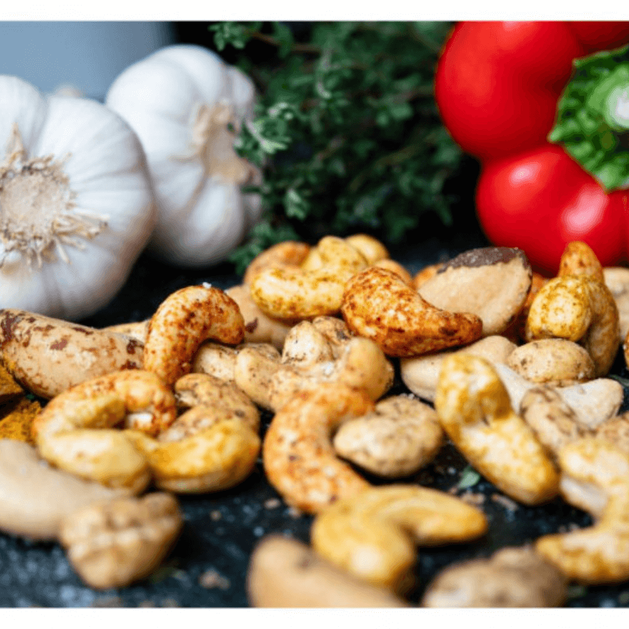 Cashews mit Knoblauch und Paprika im Hintergrund