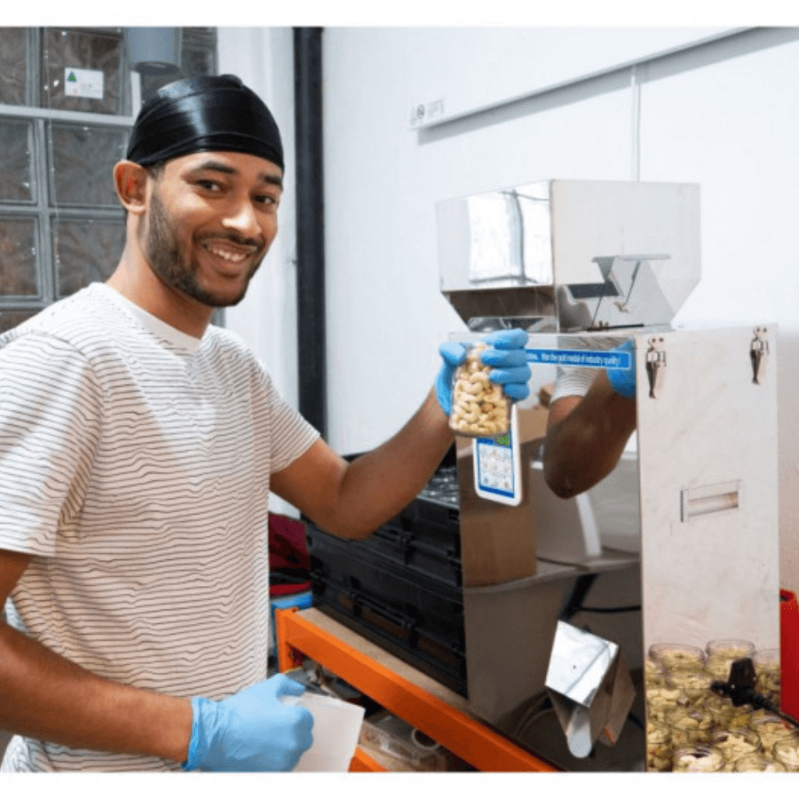 Mann hält Tüte mit Cashews in der Produktion in der Hand