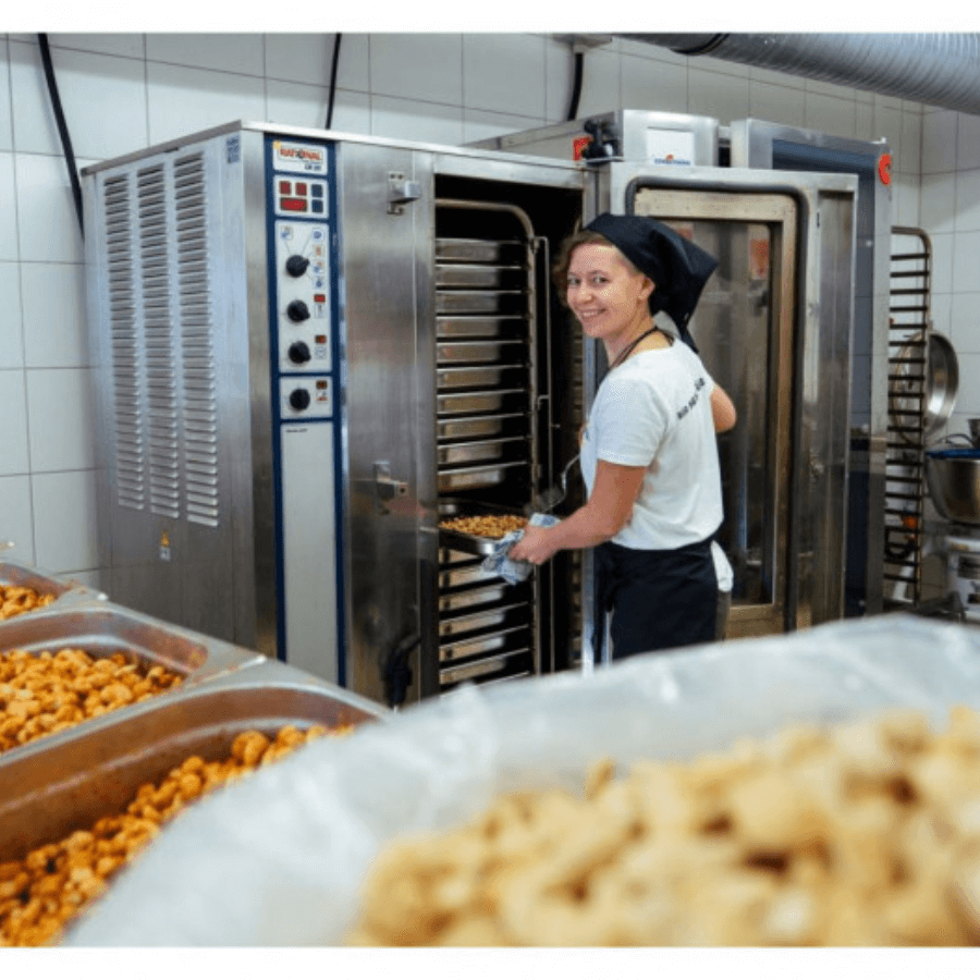 Frau steht am Ofen in der Produktion