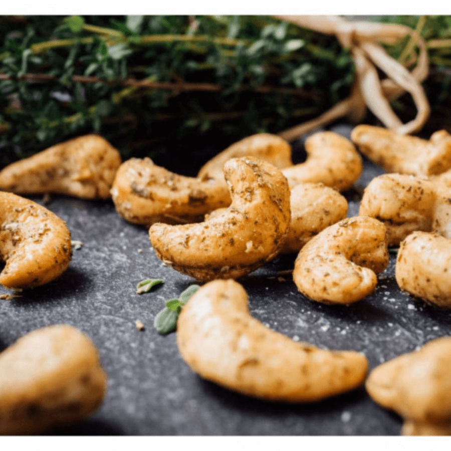 Cashews mit Rosmarien im Hintergrund