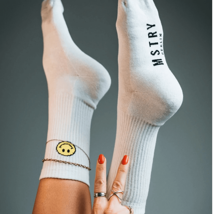 Mstry Socken Smile an Füßen, die in die Luft ragen