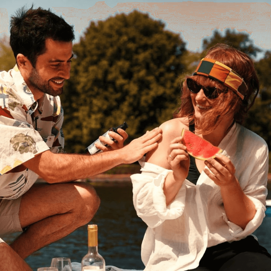 Eine Person wird von einer anderen mit der Sonnencreme eingecremt