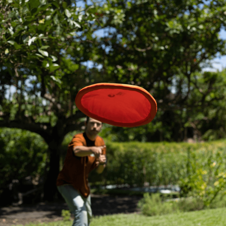 Person wirft Ultimate Moon Disc Orange