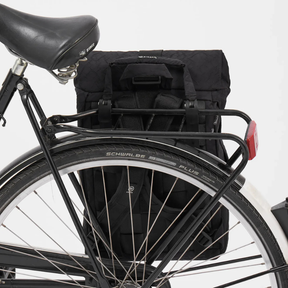 Rucksack mit Fahrradhaken von Airpaq an einem Gepäckträger befestigt
