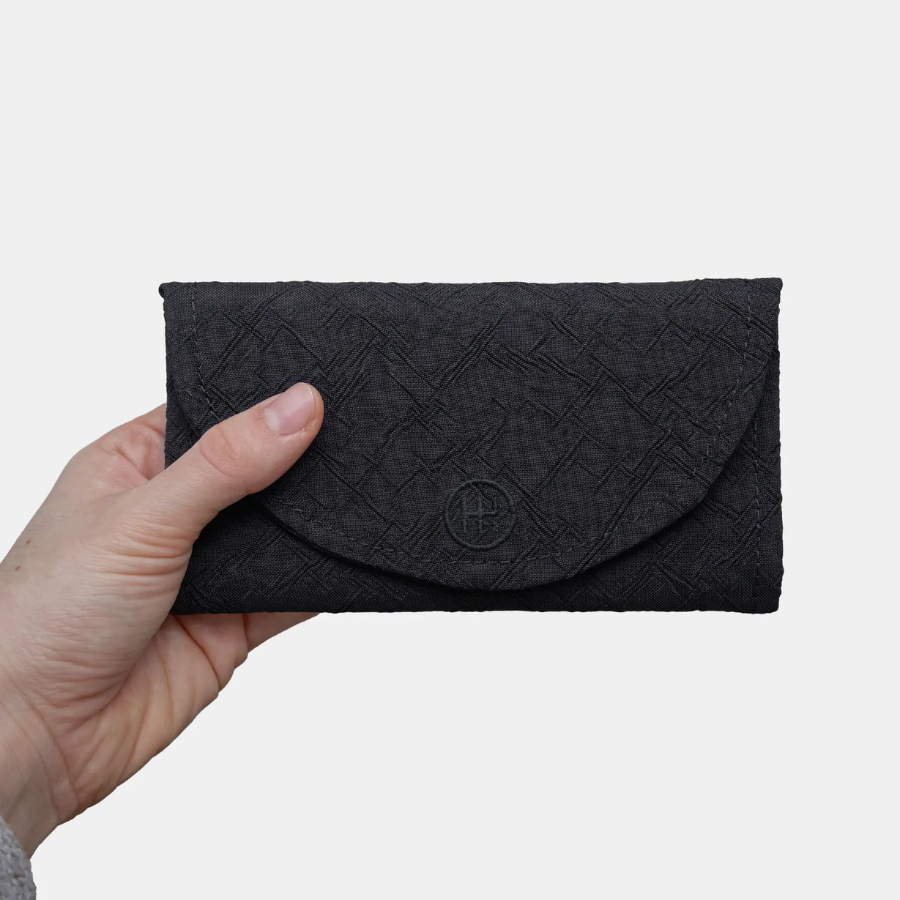 Eine Hand hält die Geldbörse von Airpaq 