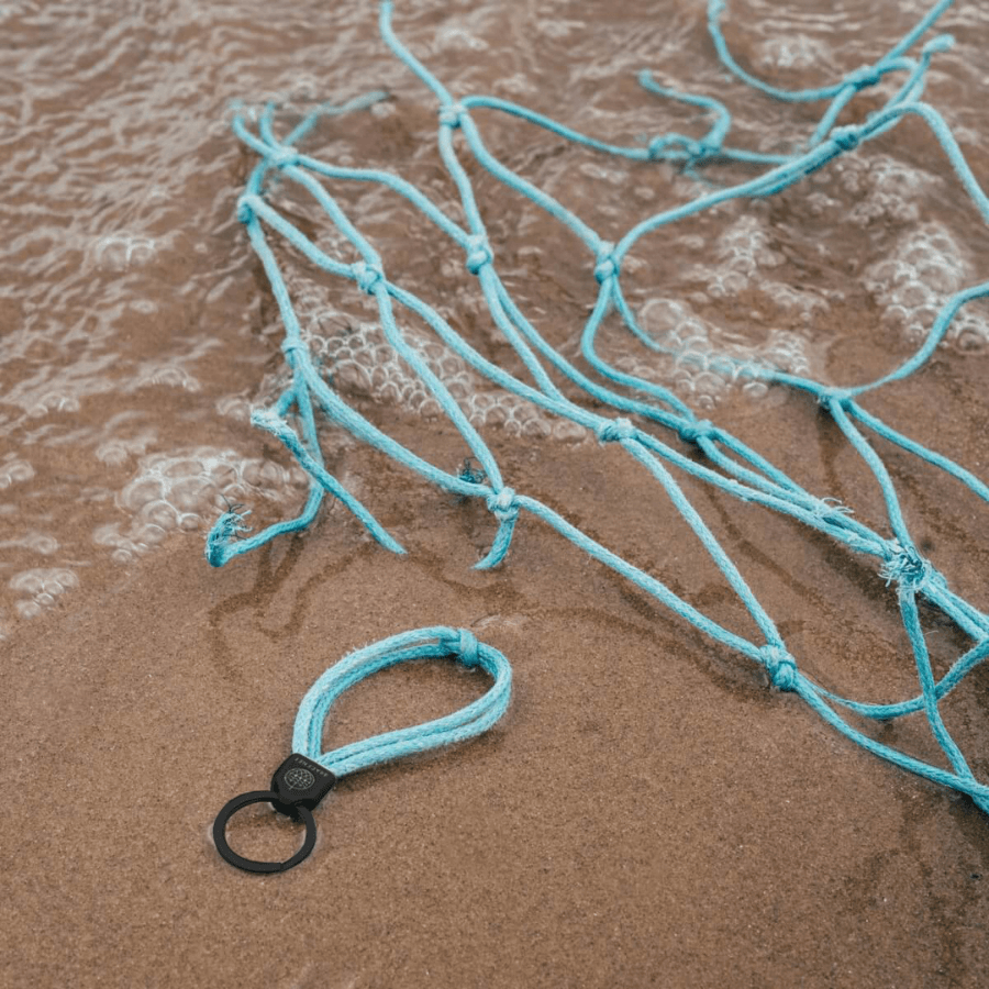 Schlüsselanhänger von Bracenet North Sea liegt am Strand
