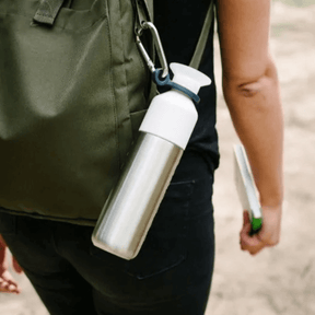 Dopper Flasche hängt mit dem Carrier an einem Rucksack