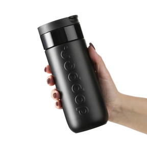 Person hält den Travel Mug 400 ml Black von Dopper in der Hand