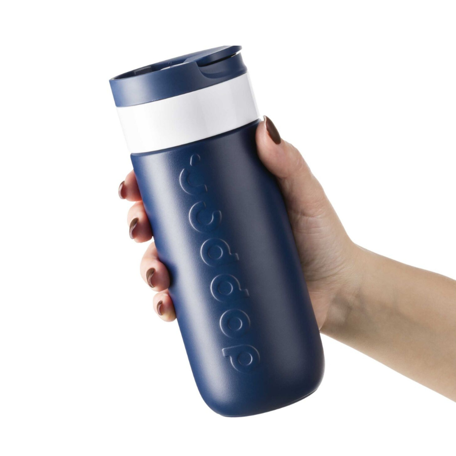 Person hält den Travel Mug 400 ml Blue von Dopper in der Hand