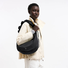 Person trägt die Moon Bag Ruffle von Got Bag – Monochrom Black über der Schulter
