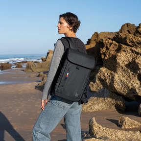 Person trägt den Serene Pack von Got Bag Black am Meer