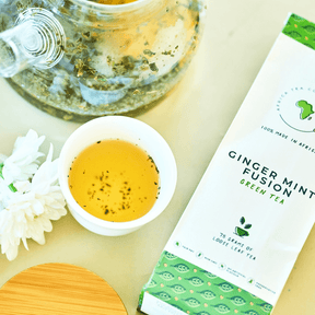 Kazi Yetu Tee Ginger Infusion 75 g loser Tee – Verpackung von vorne , daneben aufgebrühter Tee und Zutaten in Schälchen