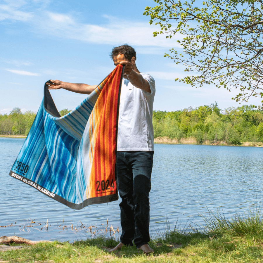Person breitet Langbrett Klimahandtuch 2024 aus