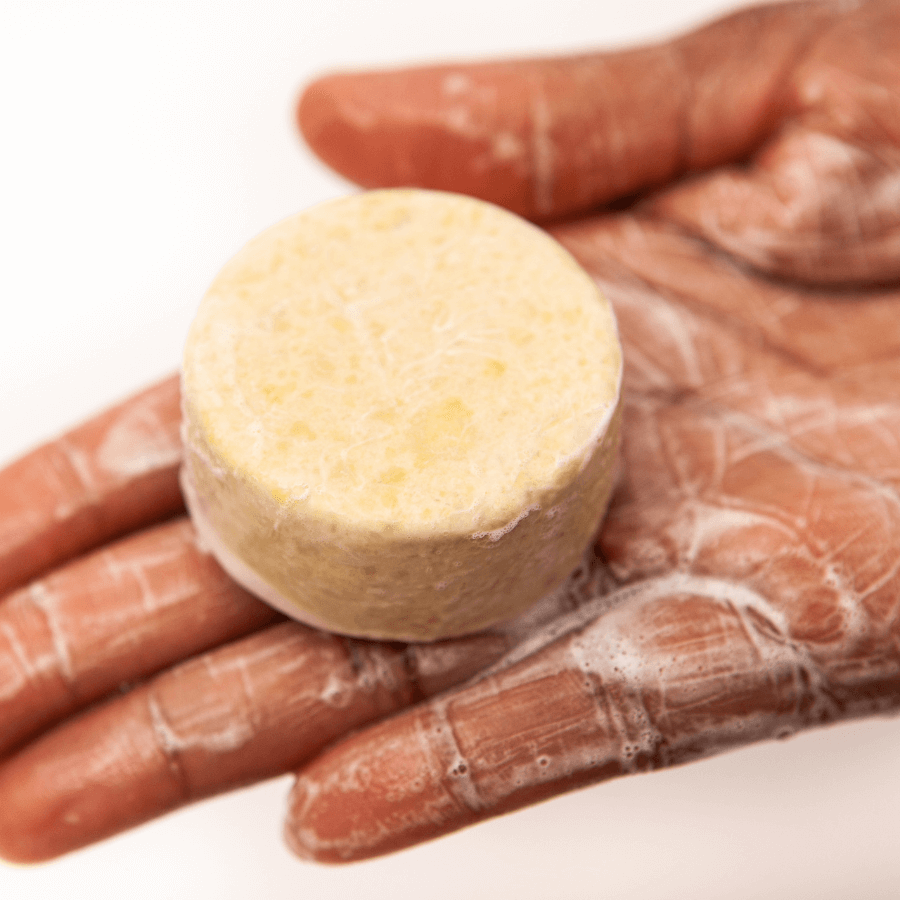 Aufgeschäumtes festes Shampoo von Omaka in einer Hand 