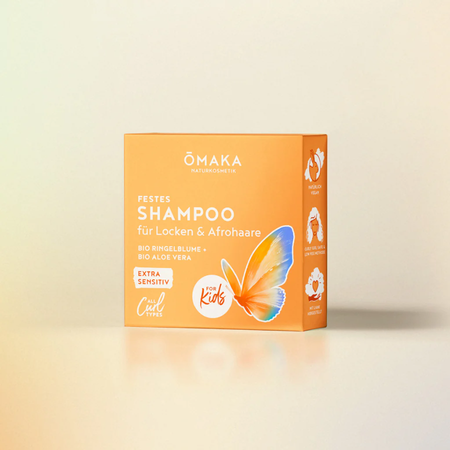 Mildes Kindershampoo von ŌMAKA – Verpackung vor hell-orangenen Hintergrund