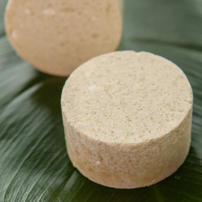 Mildes Kindershampoo von ŌMAKA – zwei Seifenstücken auf einem Bananenblatt