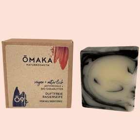 Feste Rasierseife von Omaka mit Verpackung vor orangenen Hintergrund