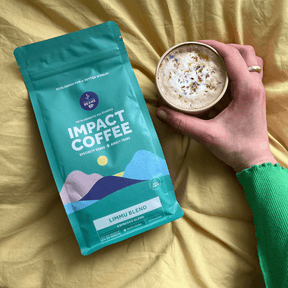 Limmu Espresso Verpackung von Plastic2Beans liegt auf einem goldenen Tuch, daneben eine Hand, die eine Tasse Kaffee hält