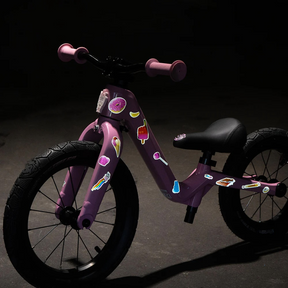 Reflexierende Sticker & Formen – Größe M. Motiv Sweets an einem rosa Kinderfahrrad im Dunklen