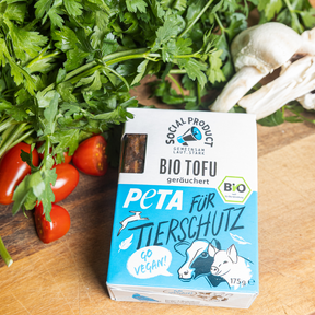 Die Bio-Tofu Verpackung von social product liegt neben Gemüse