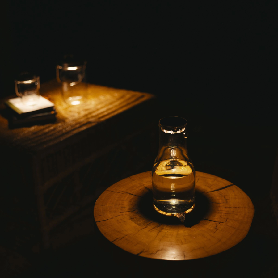 Sonnenglas Lichtkaraffe mit Solarmodul steht auf einem Baumstumpf-Tisch