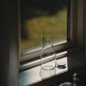 Sonnenglas Lichtkaraffe mit Solarmodul steht auf einer Fensterbank