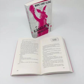 Die Känguru-Rebellion von Mark-Uwe Kling, davor ein aufgeschlagenes Buch