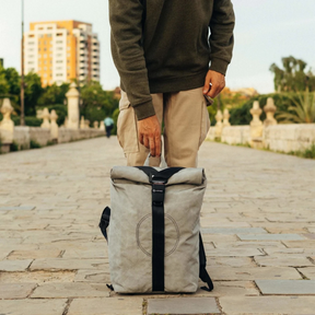 Person hält den grauen Rolltop Big von airpaq vor den Füßen