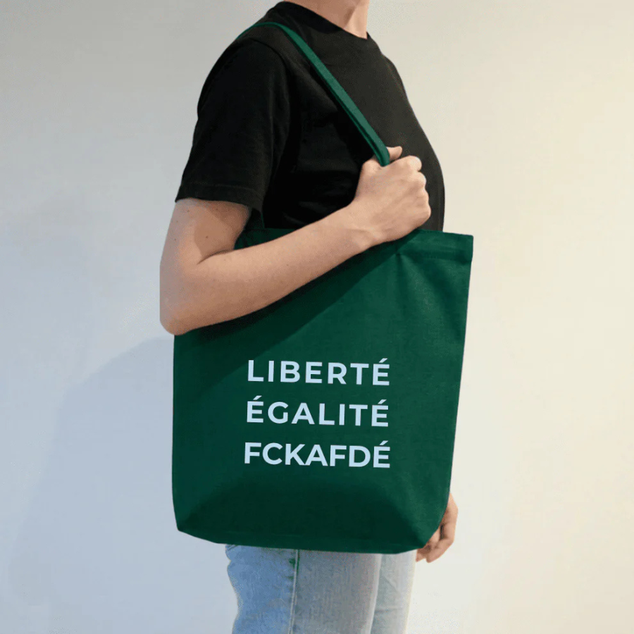 Person trägt Tote Bag – LIBERTÉ ÉGALITÉ FUCK AFD von arrel Grün mit heller Schrift 