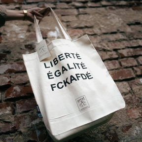Tote Bag – LIBERTÉ ÉGALITÉ FUCK AFD von arrel wird vor einer Mauer gehalten
