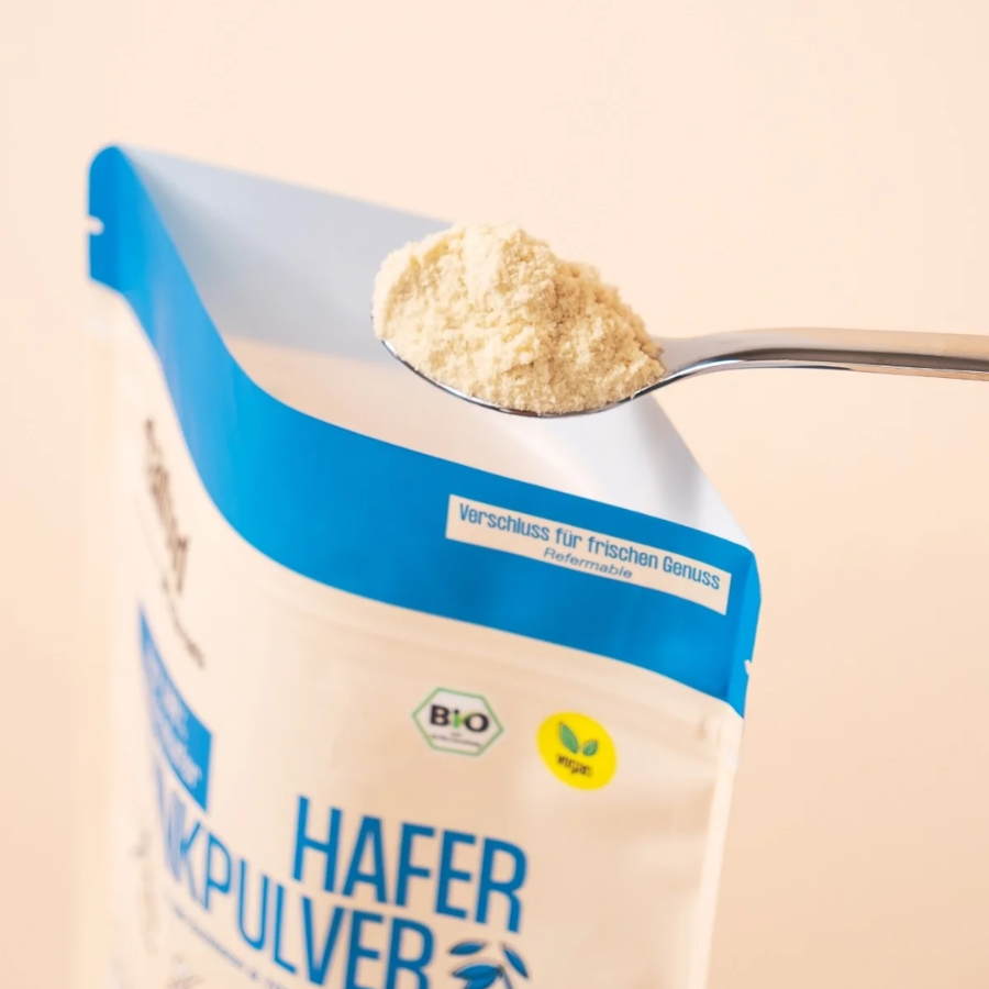 Ein Löffel Haferdrinkpulver wird aus dem 360g Beutel fairfood Haferdrinkpulver genommen