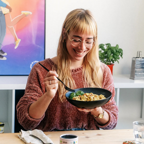 Person isst die Faire Nuss Carbonara von fairfood