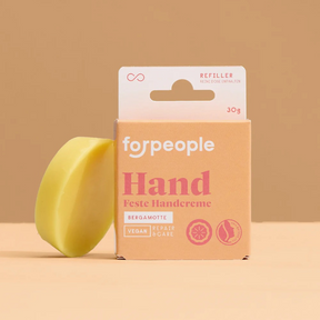 Feste Handcreme – Bergamotte (vegan) von forpeople mit Nachfüller vor orangenen Hintergrund