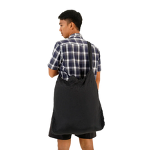 Person trägt die Faltbare Tragetasche – Eco Bag Large von Ticket to the Moon – Black über der Schulter