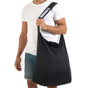 Person trägt die Faltbare Tragetasche – Eco Bag Large von Ticket to the Moon – Black seitlich