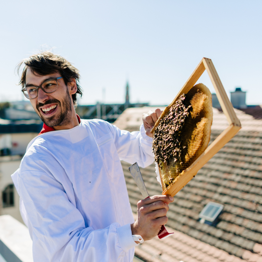 Stadtbienen Imkerkurs Teilnehmer hält Honigwaben hoch