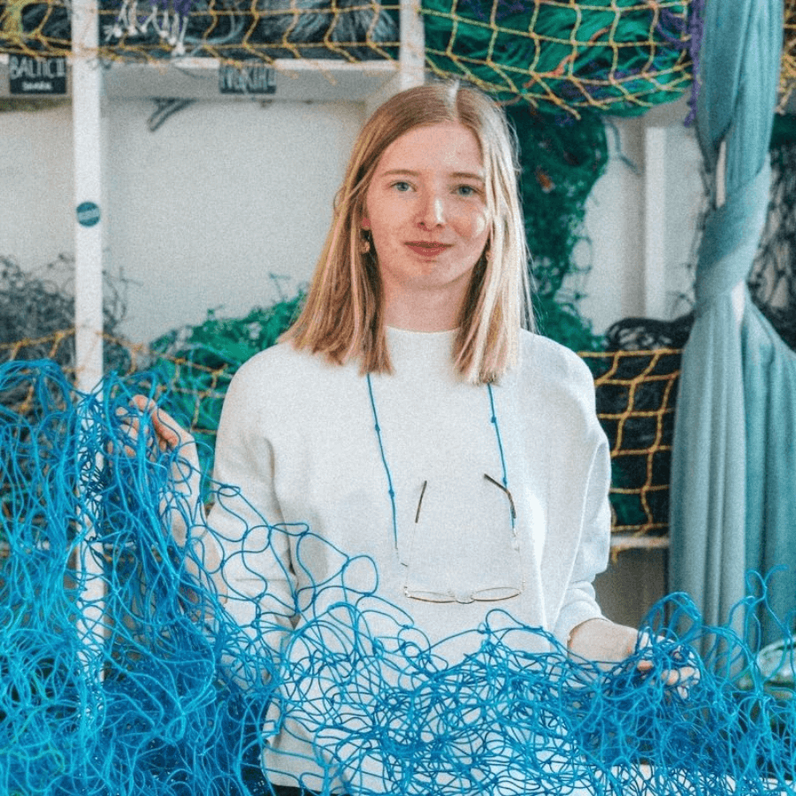 Frau steht hinter einem Fischernetz in der Farbe Arctic Ocean