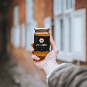Glas voll Glück - Berliner Honig wird in der Hand gehalten